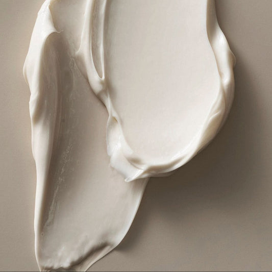 Close-up of smooth, white cream on a beige background